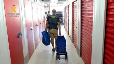 Agentes de la Guardia Civil transportan efectos recuperados en un trastero
