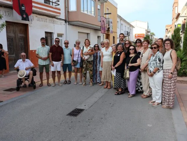 Imagen: Grupo de personas posando en una calle durante la inauguración de una exposición de arte al aire libre.