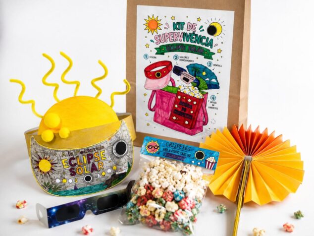El «Kit de supervivencia» que convierte el eclipse de 2026 en una aventura en Benitatxell 4 Imagen: Kit con visera solar, gafas de eclipse, bolsa de papel decorada, abanico amarillo y palomitas de colores sobre una superficie blanca.