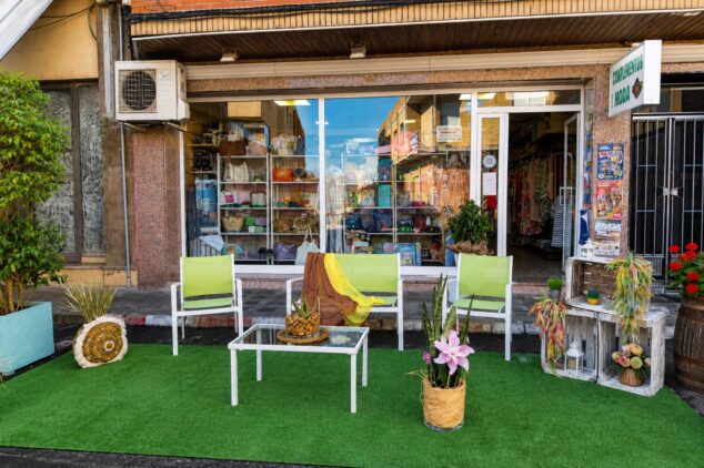 «Cambiemos los aparcamientos por jardines»: la iniciativa del comercio local de Ondara 6 Imagen: Escaparate de una tienda local con un pequeño jardín efímero con sillas y decoración en la acera.
