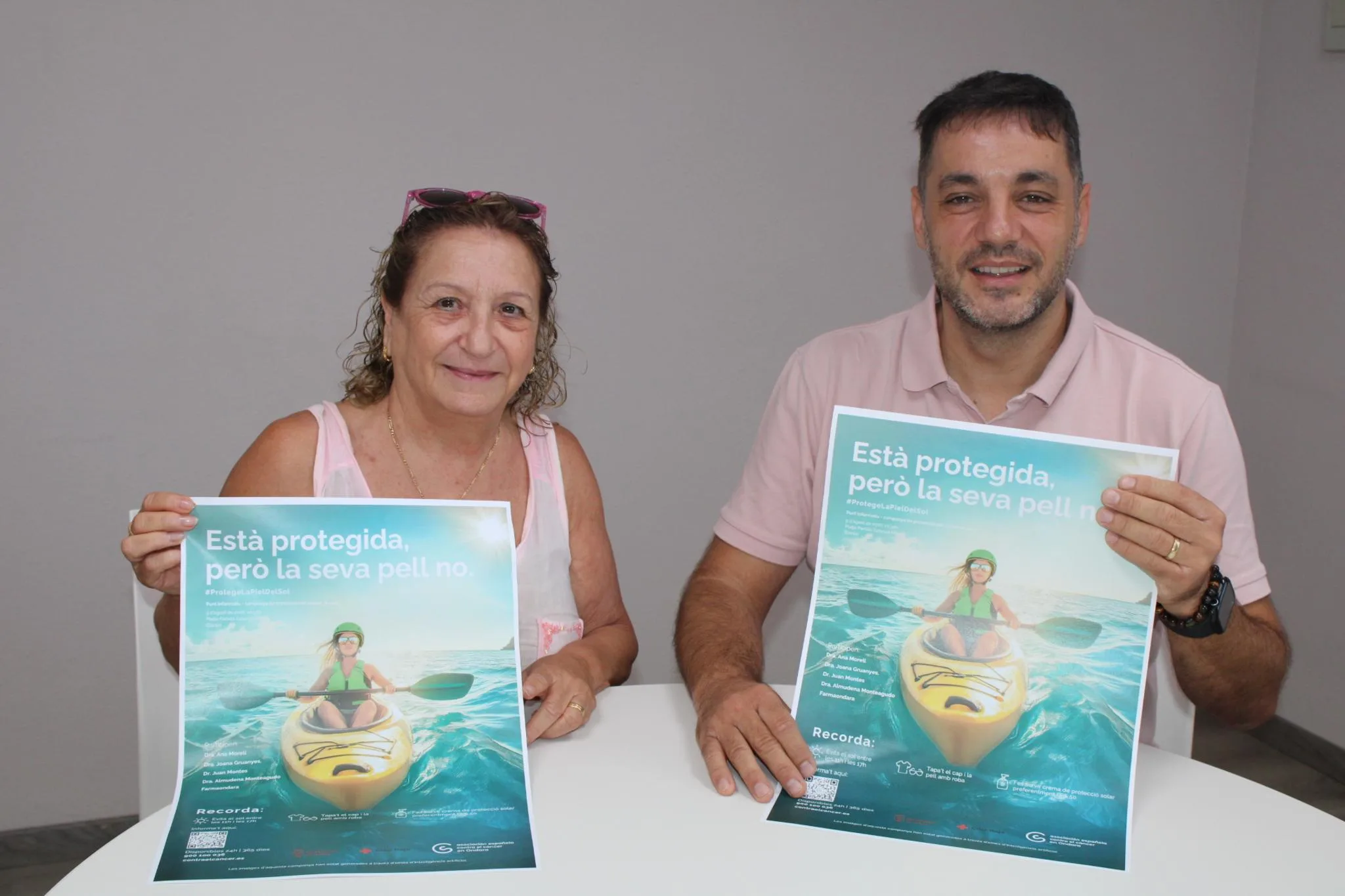 Mª Carmen Bisquert y José Ramiro sostienen el cartel de la campaña de prevención del cáncer de piel.