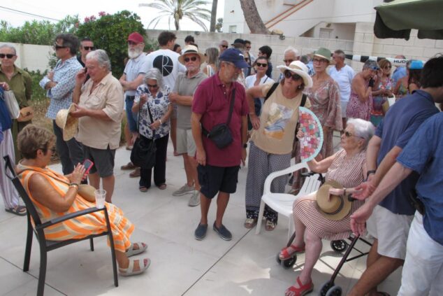 Grupo de personas, incluyendo representantes de la Generalitat y vecinos afectados, reunidos al aire libre en Dénia para tratar el tema de los deslindes costeros.
