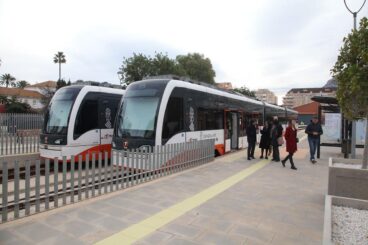 Dos trenes del TRAM d'Alacant parados en la estación de Dénia con pasajeros bajando al andén.