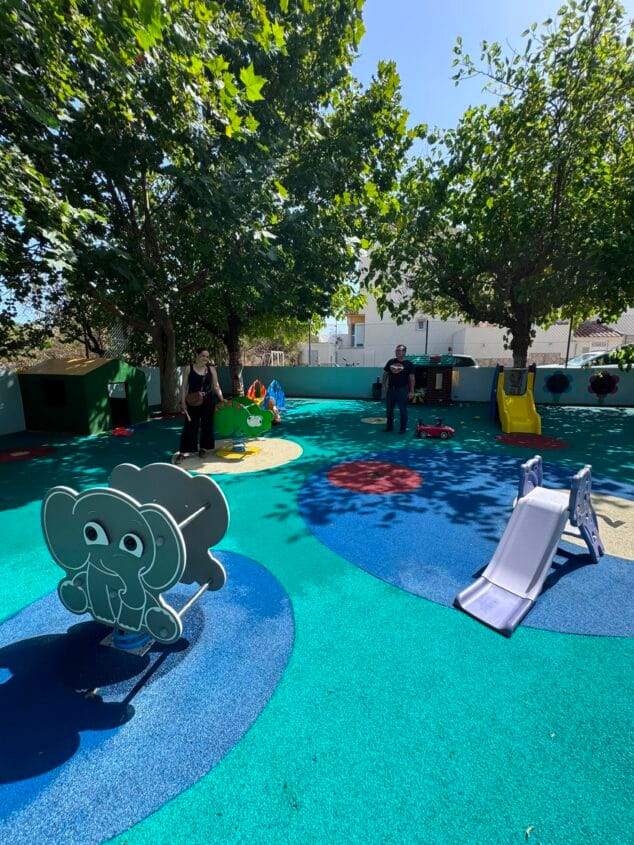 Ondara renueva el parque infantil de la Escuelita Joaquina Gavilà 3 Miguel Gomis y Rosa Ana Marí de pie en el nuevo parque infantil con suelo de colores y juegos de la Escoleta Joaquina Gavilà de Ondara.