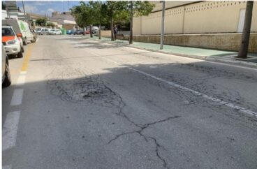 Calle con asfalto deteriorado en una urbanización de Calp