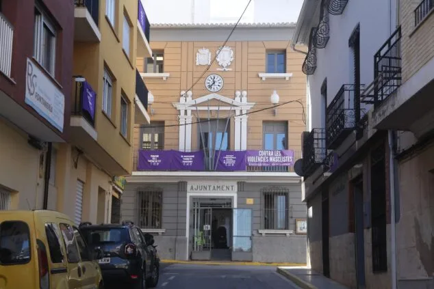 Fotografía de la fachada principal del edificio del Ayuntamiento de Pedreguer con coches aparcados delante.