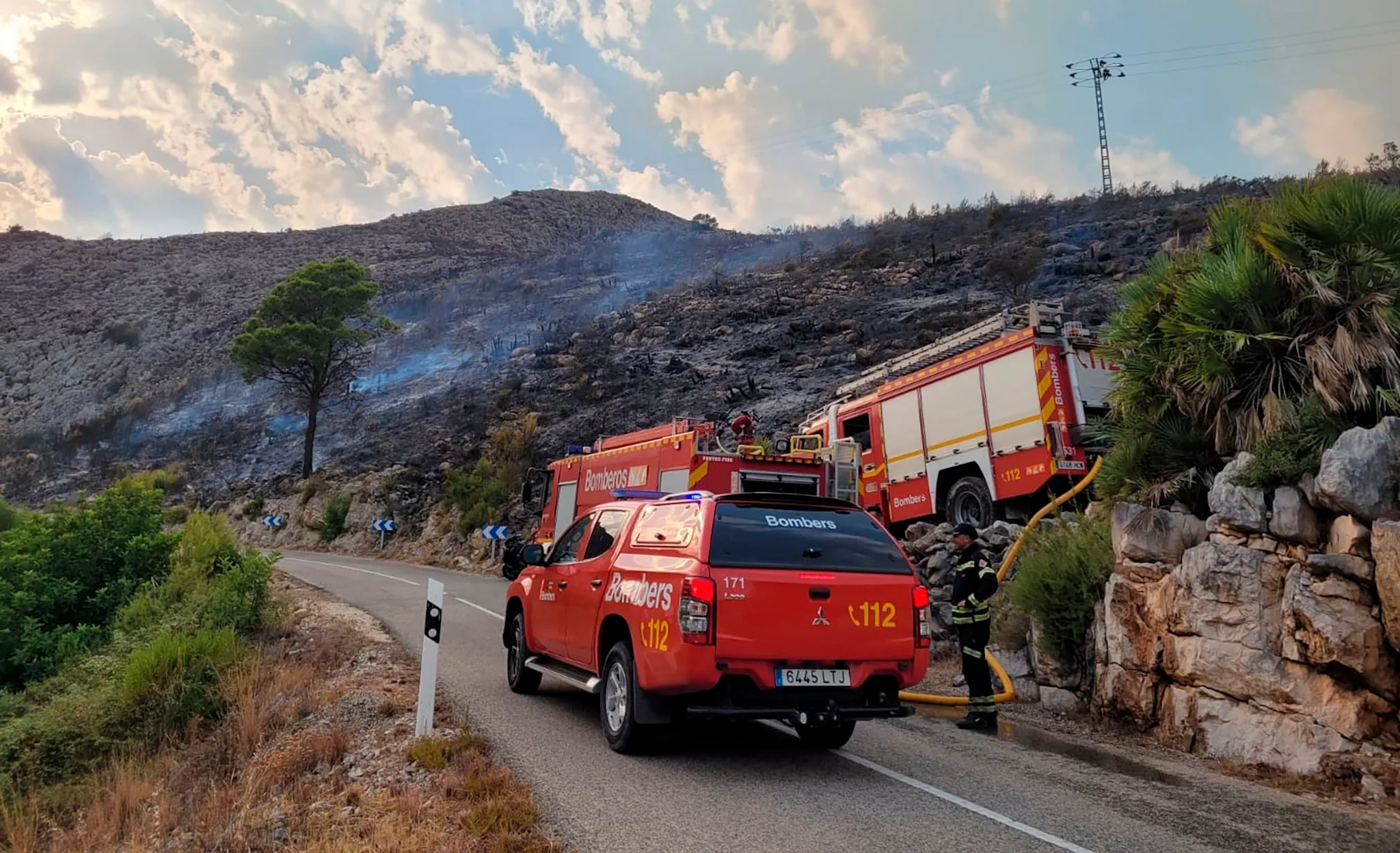 foto de archivo de bomberos trabajando en el monte de la marina alta