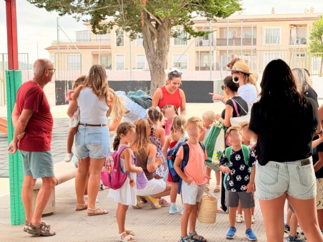 Familias y alumnos con mochilas reunidos en el exterior del CEIP Santa María Magdalena en el primer día de colegio.