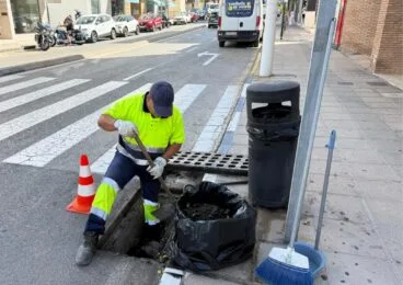 Un operario municipal limpia un imbornal con una pala en una calle de Teulada como medida preventiva ante las lluvias.