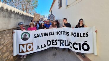 Salvem la Vall organiza en Parcent el FESVALL 2026 con el foco puesto contra el PAI Medina de Llíber 3 Un grupo de personas sostiene una pancarta blanca grande que dice "SALVEM ELS NOSTRES POBLES NO A LA DESTRUCCIÓ" y tiene el logo de "Salvem la Vall" durante una manifestación en una calle.