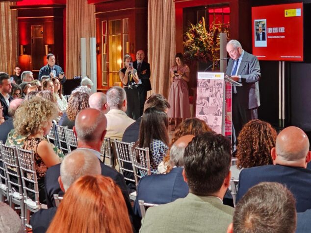 Imagen: El ministro Jordi Hereu hablando desde un atril en un evento, con una pantalla detrás que muestra su nombre y cargo.