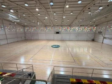 Vista interior de la pista de parqué renovada del Pavelló Ifac de Calp con el logo central.
