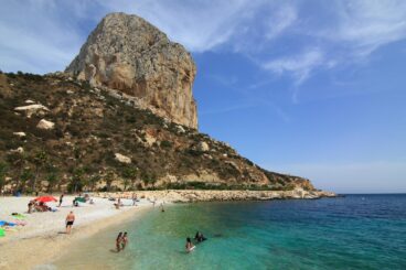 Científicos y pescadores debaten sobre la Reserva Marina del Penyal d’Ifac en Calp 3 Vista costera del Penyal d'Ifac en Calp con bañistas y personas practicando snorkel en aguas claras.
