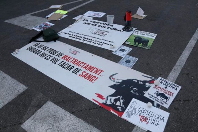 Varios carteles y una pancarta grande contra la tauromaquia y el maltrato animal, con el logo de 'Ondara sense crueltat animal', colocados en el suelo.