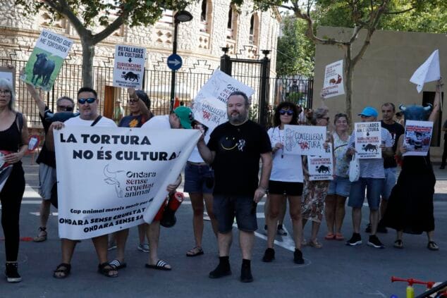 Imagen: Grupo de personas manifestándose con pancartas y carteles antitaurinos en una calle de Ondara.