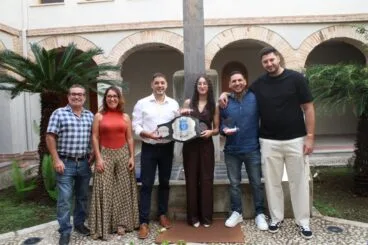 Mariama Charki posa con su cinturón de campeona de boxeo autonómico, su entrenador Nito Pinargote y el alcalde y concejales de Ondara en el claustro del ayuntamiento.