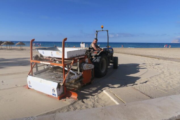Imagen: Tractor con maquinaria de cribado trabajando en la arena de la playa de Calp con el peñón de Ifach al fondo.
