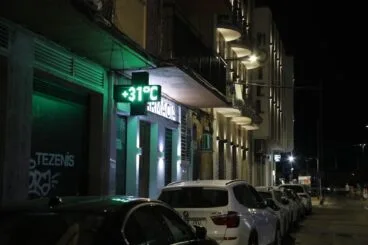Termómetro de una farmacia marcando 31 grados durante la noche en una calle de Dénia.