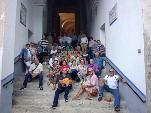La junta directiva de jubilados de Benitatxell anuncia su despedida tras siete años 1 Imagen: Gran grupo de personas mayores de Benitatxell posando en unas escaleras de piedra durante una salida cultural.