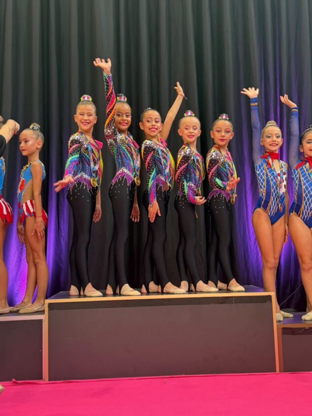 Imagen: Gimnastas del Club Les Marines celebran en el podio con medallas.