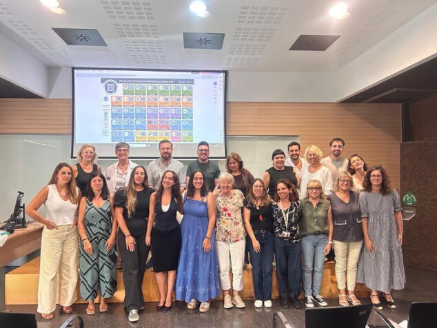 Imagen: Foto de grupo de los miembros de la Comisión de Salud Mental de la Marina Alta posando frente a una pantalla de proyección.