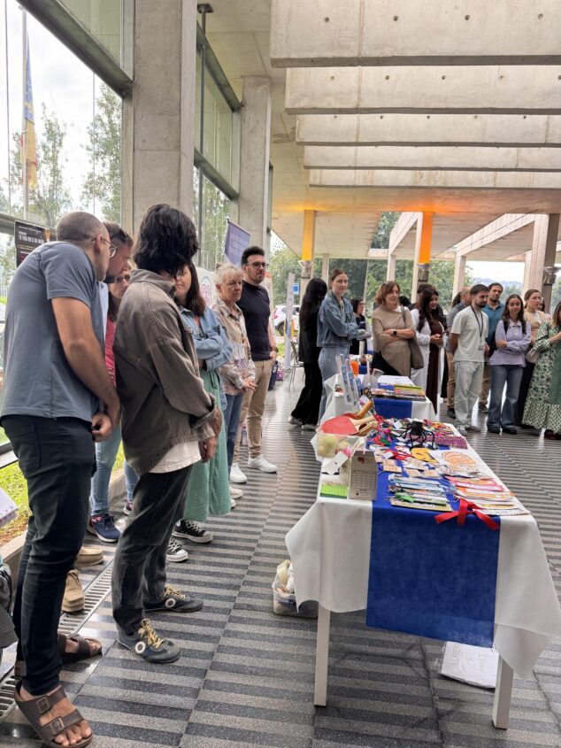 Imagen: Personas visitando mesas informativas durante un encuentro sobre salud mental en un edificio moderno.