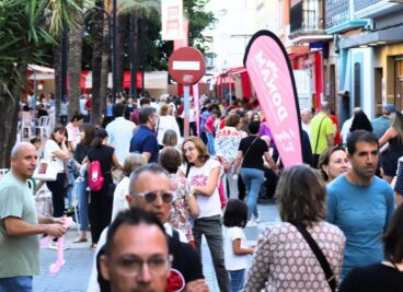 Calle concurrida con visitantes y puestos durante la Fira Gata al Carrer.