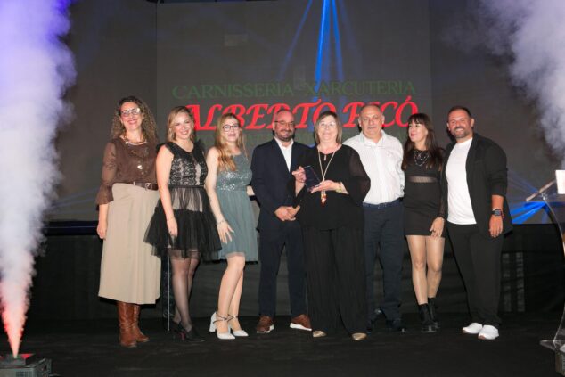 Ondara homenajea al tejido empresarial local en la III Gala del Comercio y Empresas 6 Grupo de personas en un escenario recibiendo un premio, con una pantalla de fondo que dice 'CARNISSERIA-XARCUTERIA ALBERTO PICÓ'.