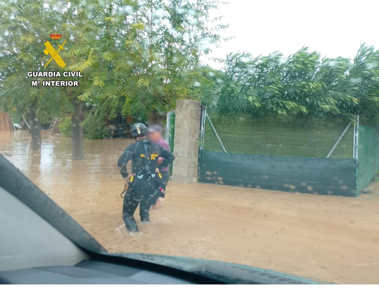 Agente del GEAS de la Guardia Civil auxilia a una persona en una zona inundada por la DANA