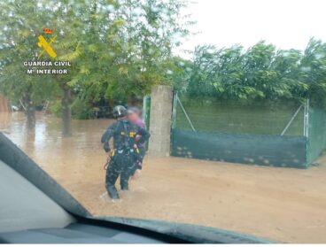 Agente del GEAS de la Guardia Civil auxilia a una persona en una zona inundada por la DANA