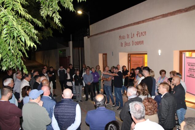 Imagen: Grupo de personas reunidas de noche frente a la entrada del Museu de la Plaça de Bous d'Ondara durante su inauguración.