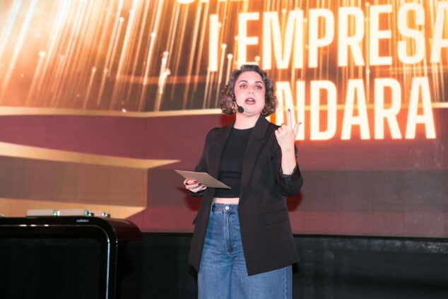Ondara homenajea al tejido empresarial local en la III Gala del Comercio y Empresas 2 Imagen: María Zamora presentando la III Gala del Comercio y Empresas de Ondara con un micrófono en el escenario.