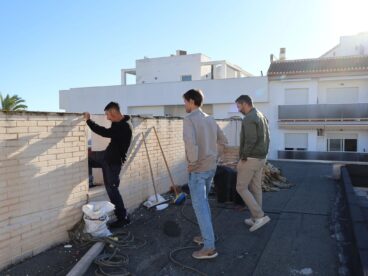 Varios hombres inspeccionan las obras en la azotea del Centro de Salud de Benitatxell.