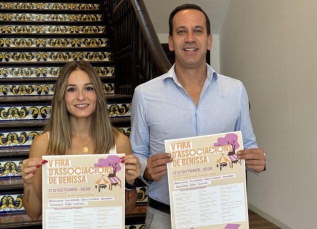 Imagen: Virginia Pérez y Arturo Poquet posan sonrientes en una escalera con azulejos sosteniendo los carteles de la V Fira d’Associacions de Benissa.
