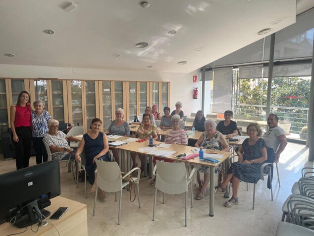 Grupo de participantes y profesora posando en un aula durante un taller del Centro Cívico de Calp.