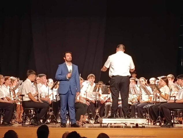 Imagen: El tenor José Monfort canta acompañado por la Unió Musical d'Ondara y su director en un escenario.