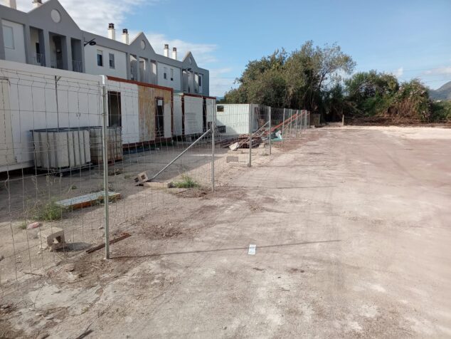 Ondara abre un nuevo aparcamiento con capacidad de 35 plazas 4 Imagen: Terreno vallado del nuevo aparcamiento público Blasco Ibáñez en Ondara con edificios al fondo.