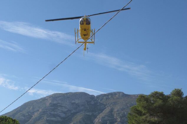 Imagen: Un helicóptero participa en la retirada de torres de alta tensión entre Dénia y Xàbia junto al Montgó