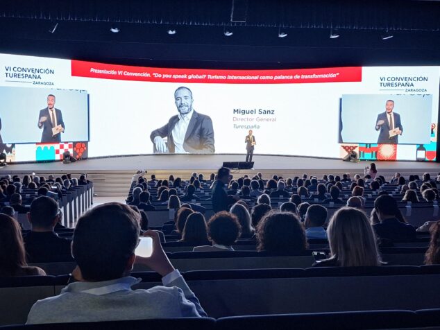 Calp diseña su promoción internacional de 2027 en la Convención Turespaña de Zaragoza 1 Miguel Sanz habla en el escenario frente a una gran pantalla en la VI Convención Turespaña.