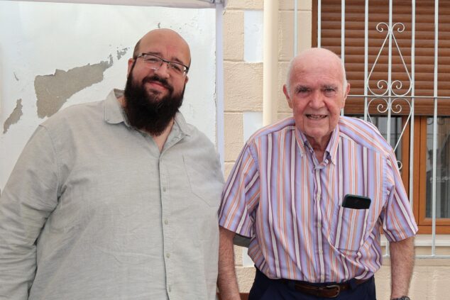 La Policía Local de Benitatxell presenta nueva unidad de drones en su día grande 4 Imagen: Vicent Bolufer, hombre mayor con camisa de rayas, posa sonriente junto a otro hombre en un evento al aire libre.